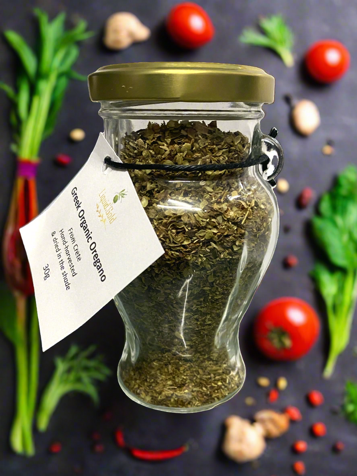 Cretan organic oregano in glass amphora jar, with fresh salad
