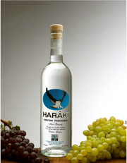 Haraki bottle with grapes on a gray background
