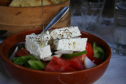 Greek herbs and spices on Greek salad and feta