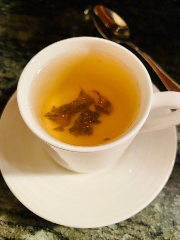 Cup of carob tea, carob pieces steeped in boiled water